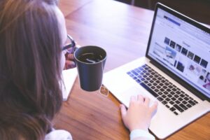 Person drinking tea while studying on a laptop