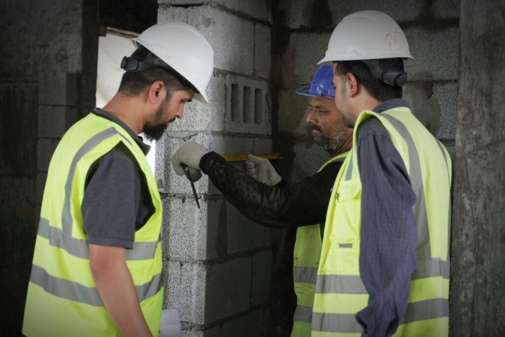 Construction workers reviewing measurements on a building site