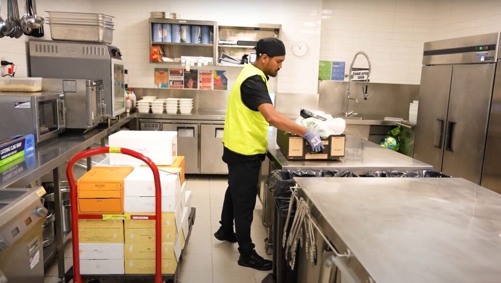 Hospitality worker unloading food supplies in a commercial kitchen
