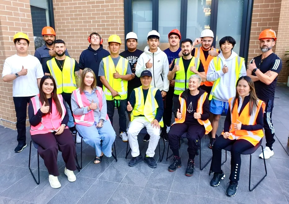 White Card graduates wearing high-vis vests and helmets posing after training.