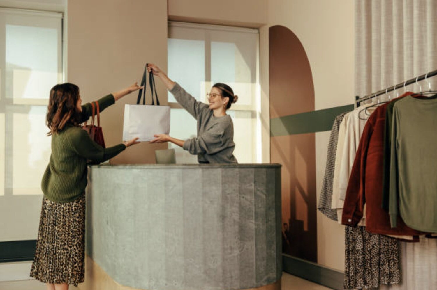 retail assistant handing a bag to a customer